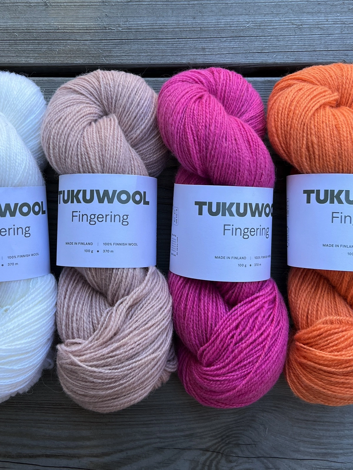 Four skeins of Tukuwool Fingering yarn in color snow white, blush pink, pink daisy, apricot